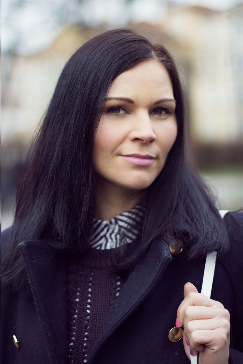 Winteroutfit mit schwarzem Mantel, Bluse und Strickpullover