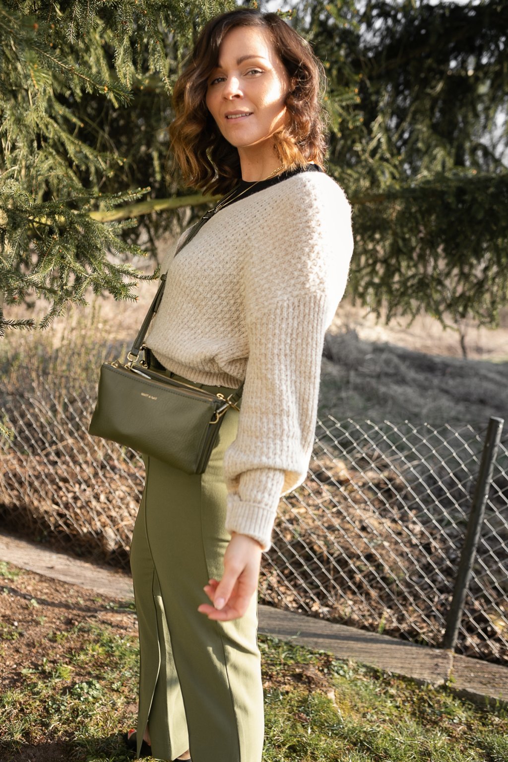 Frühlingsoutfit mit beigen Cardigan, grüner Hose und schwarzem Top ...