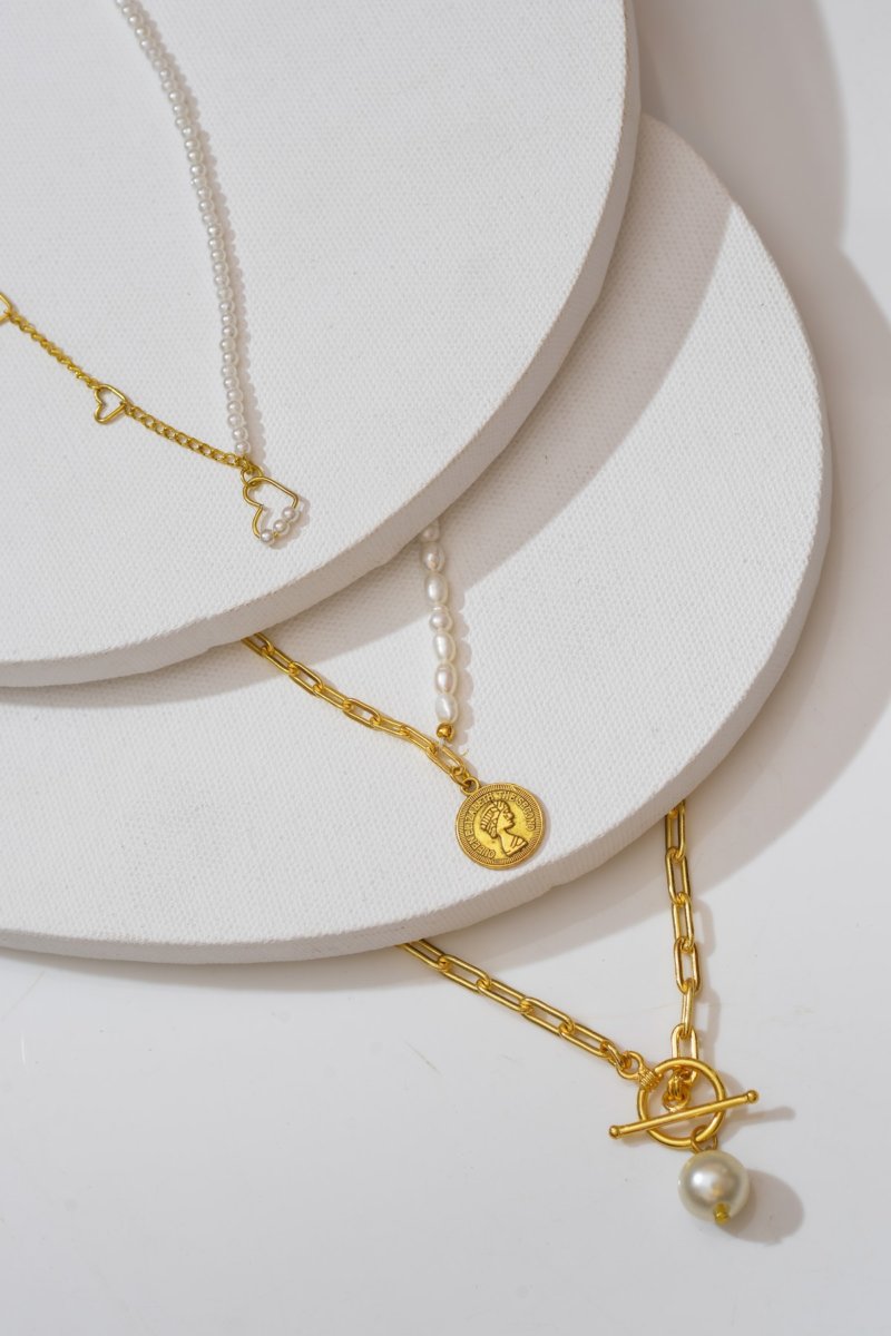 Du kannst auch mehrere schlichte Goldketten mit einer Perlenkette tragen, um die Perlenkette hervorzuheben