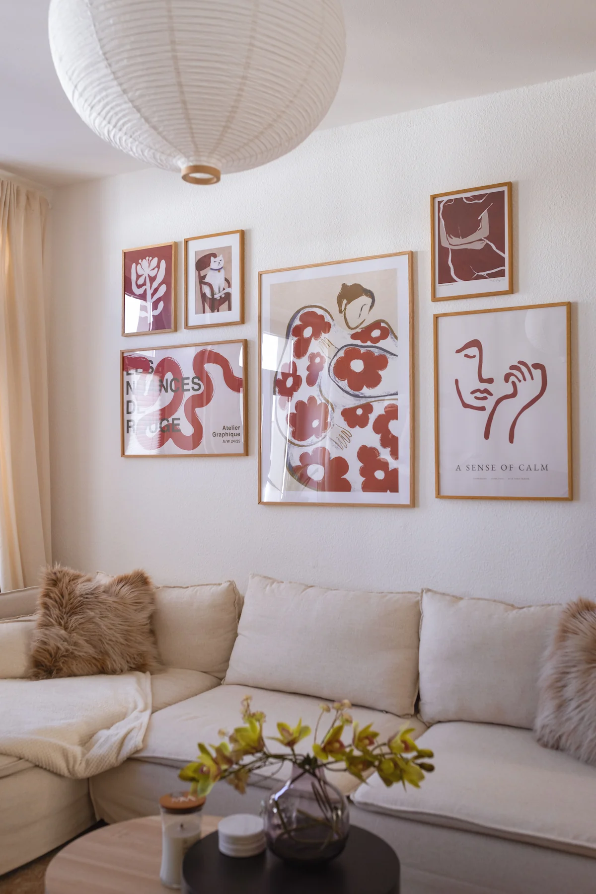 Modern picture wall in the living room with abstract posters and line art in light wooden frames