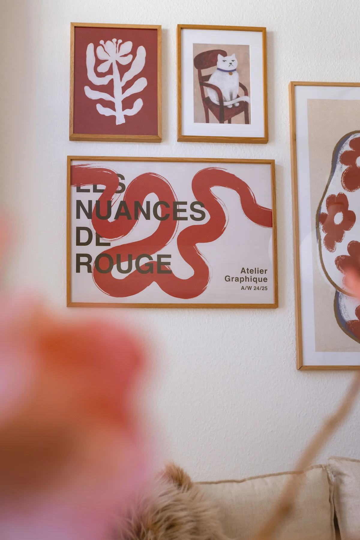 Cream-colored sofa below an abstract gallery wall with line art posters