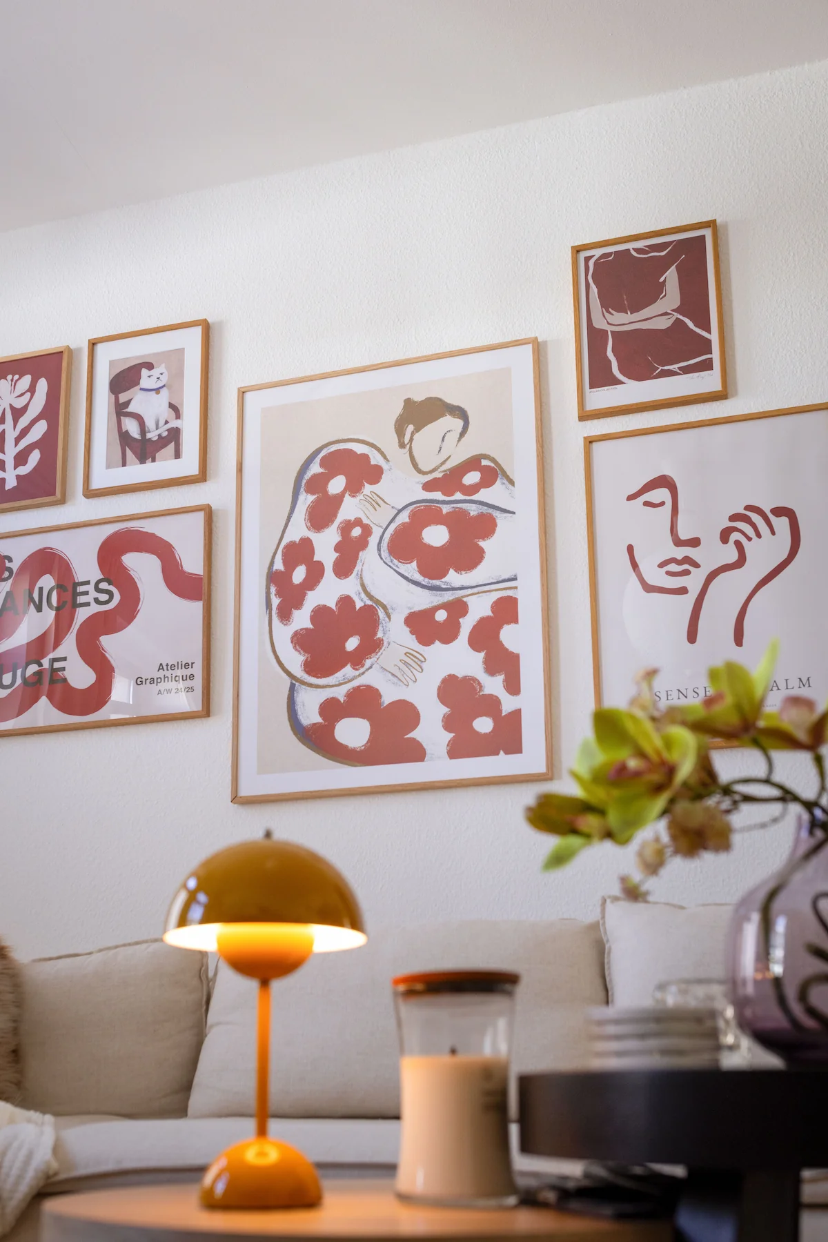 Picture wall in the living room with abstract posters and line art in light wooden frames