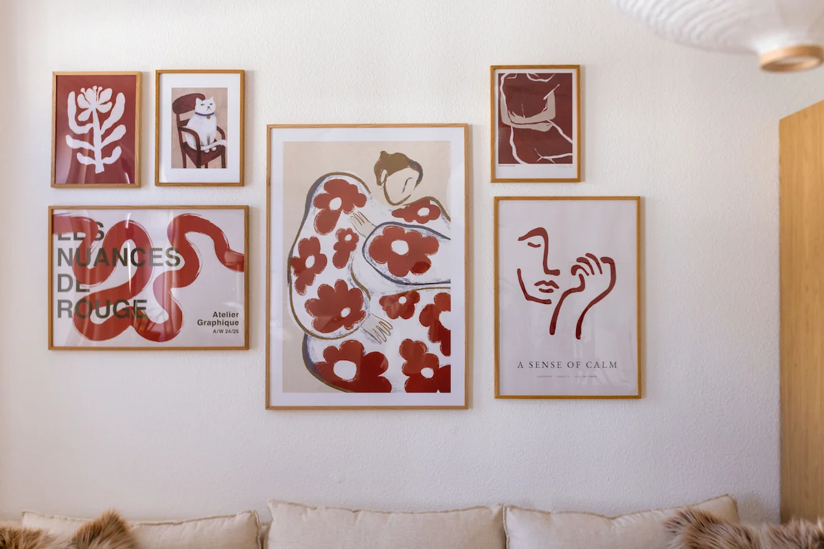 Abstract poster in a warm red tone as the focal point of a modern gallery wall