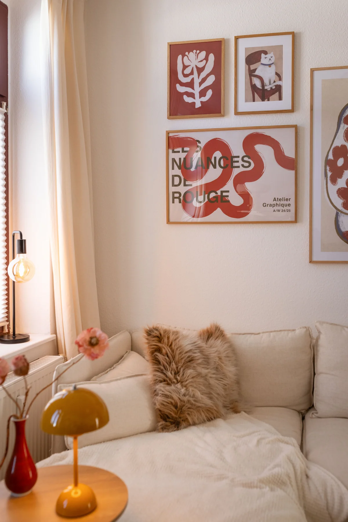 Abstract posters in warm red and beige tones as a calm wall design in the living room