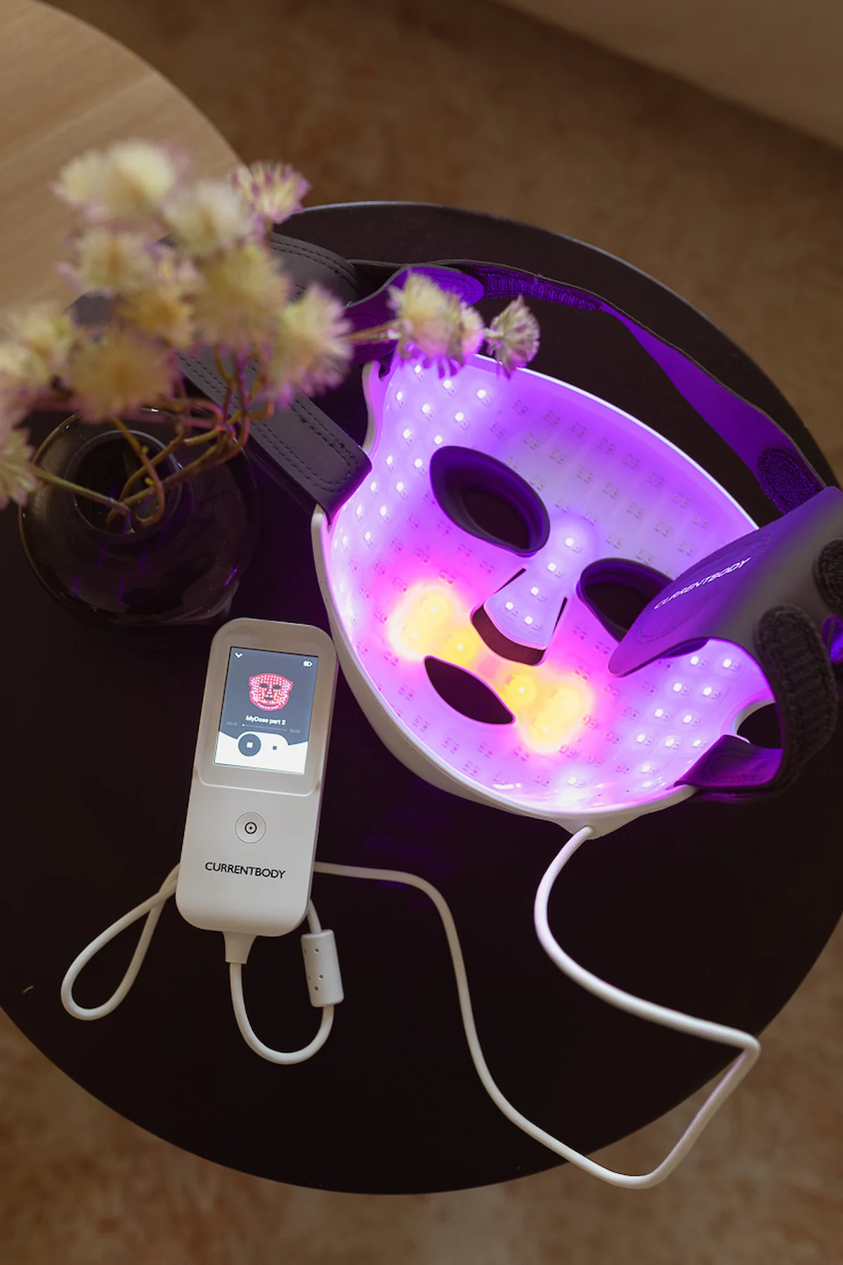 Innenseite der CurrentBody LED-Maske mit violett und gelb leuchtenden LED-Bereichen neben dem Controller.