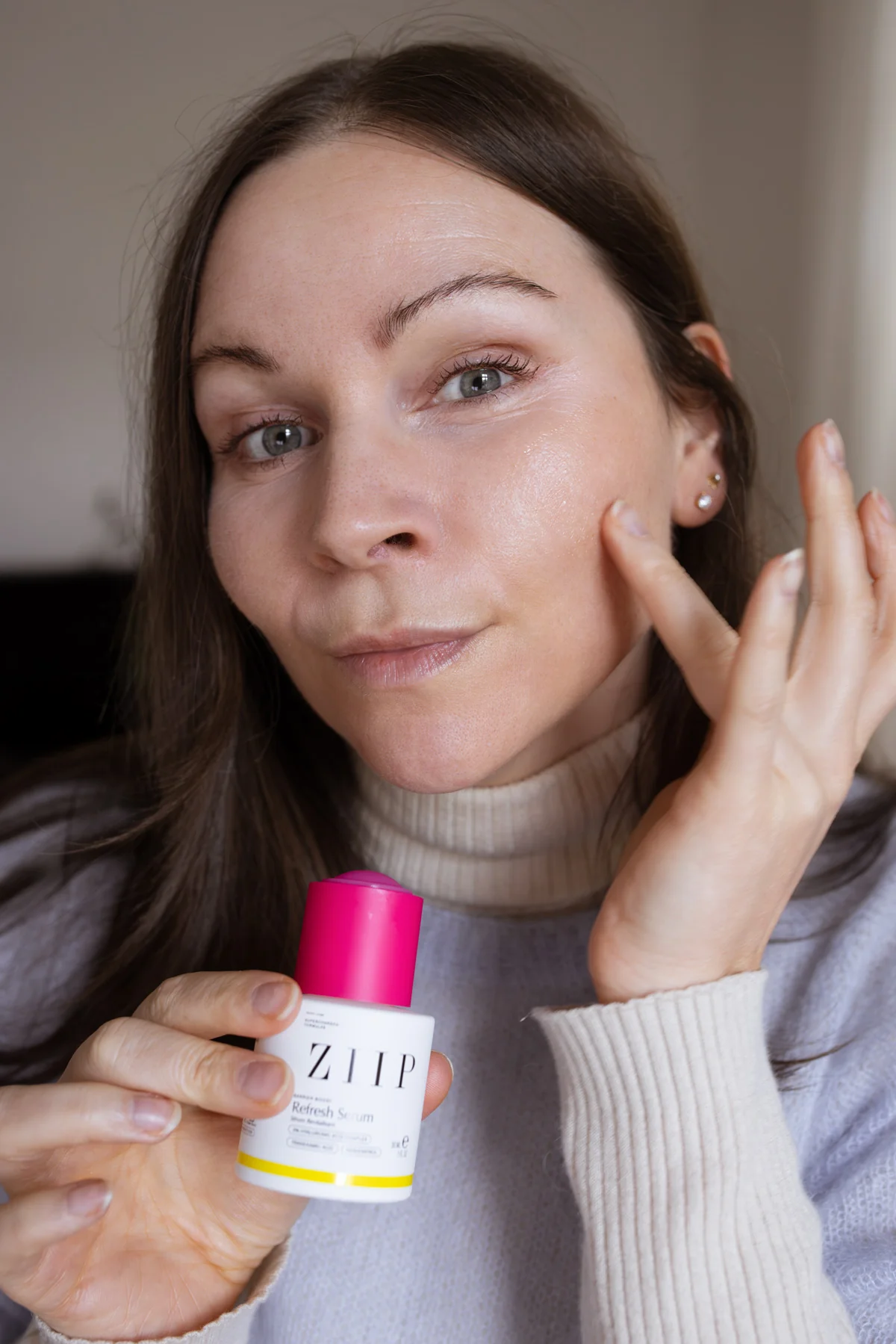 ZIIP Refresh Serum aus der Barrier-Boost-Reihe mit pinkem Verschluss neben seiner Verpackung im Test. In der Anwendung auf empfindlicher Mischhaut.
