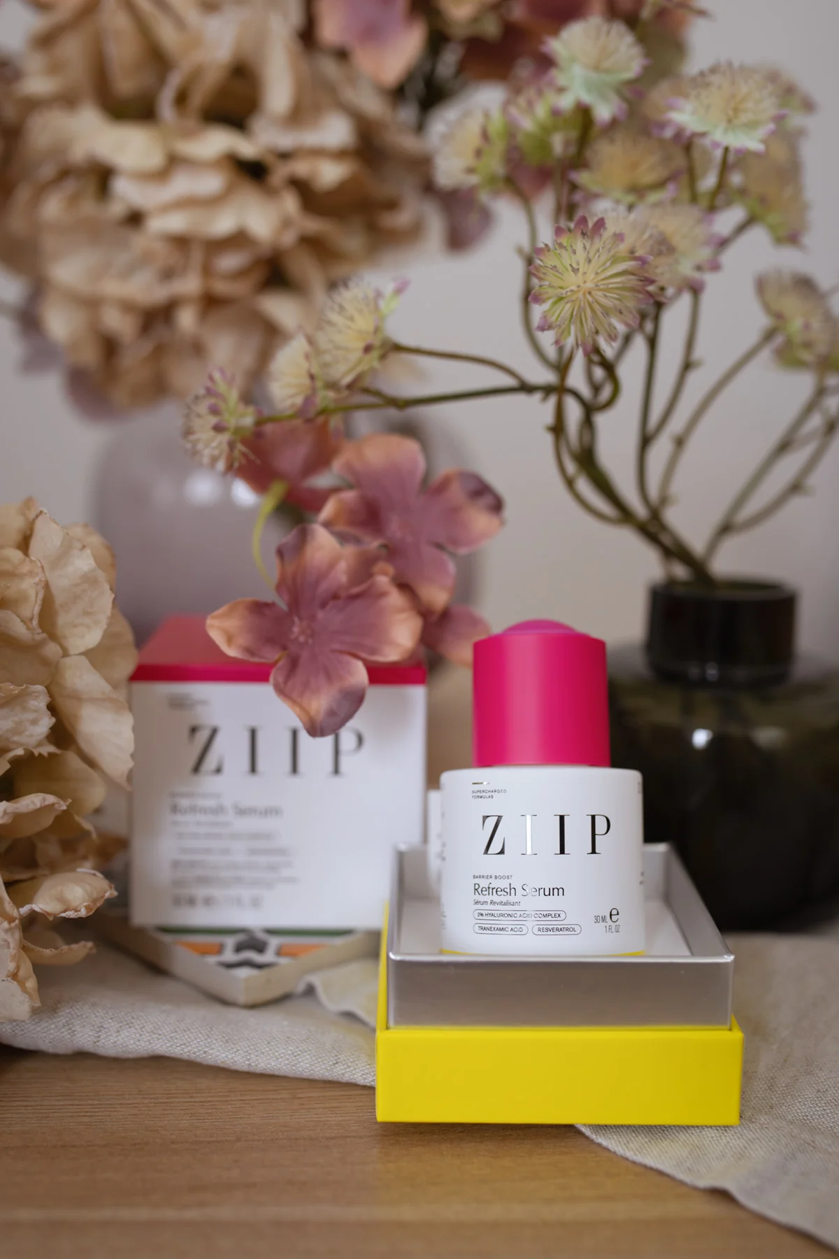 ZIIP Refresh Serum aus der Barrier-Boost-Reihe mit pinkem Verschluss neben seiner Verpackung im Test.